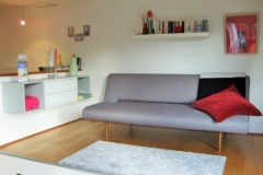 Das bequeme und moderne Sofa auf dem Podest dient als weiterer Schlafplatz